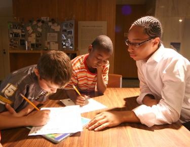 3 boys reading and doing homework